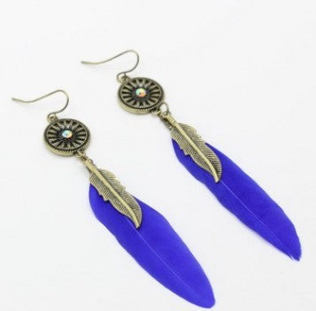 Pair of earrings with blue feather-shaped pendants on a white background