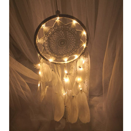 Decorative dreamcatcher with lights and feathers against a soft background