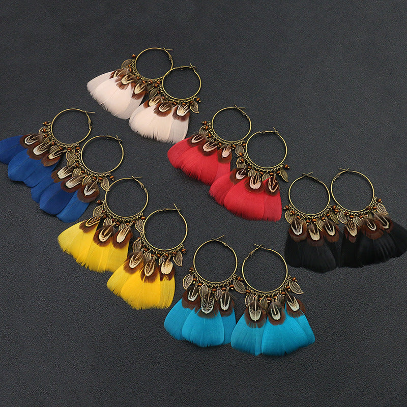 Colorful feather earrings on a dark background