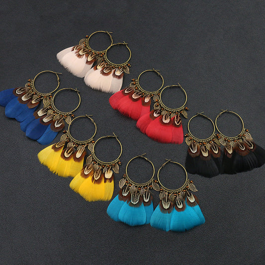 Colorful feather earrings on a dark background