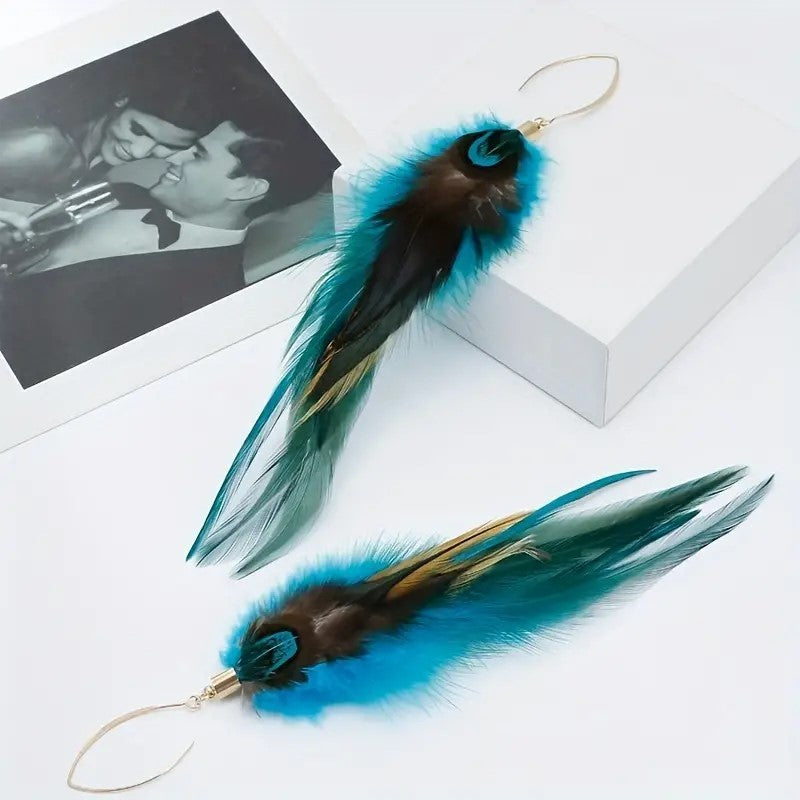 Feather earrings with blue and green feathers on a white surface.