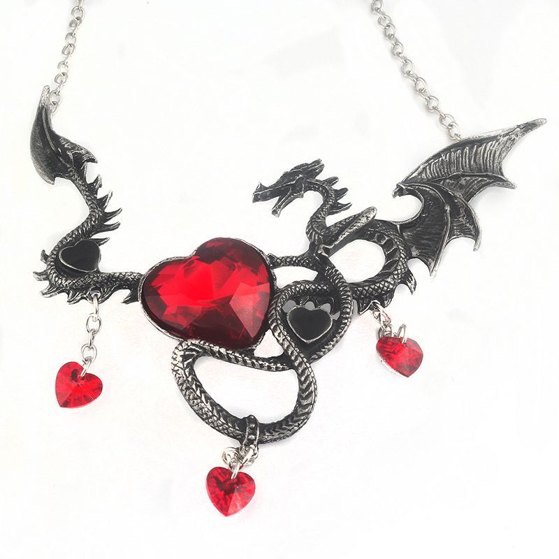 Dragon-shaped necklace with red heart stones on a white background