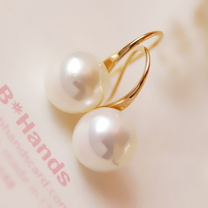 Gold ring with two pearls on a soft pink background