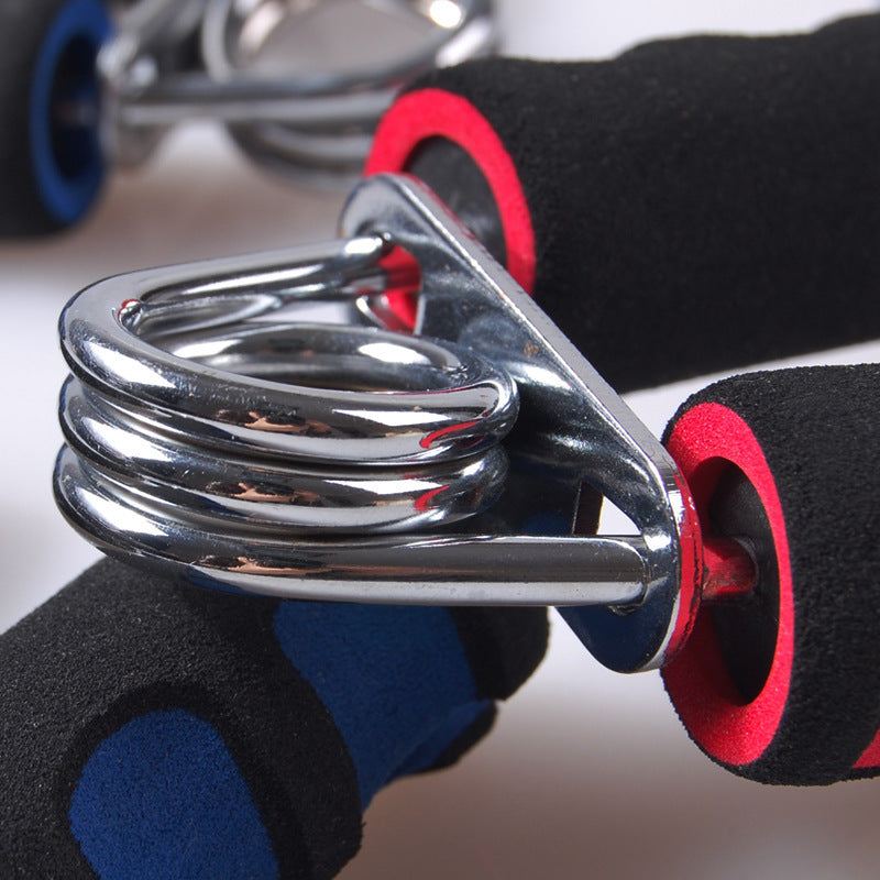Close-up of a metal spring mechanism with black and red gloves on a neutral background