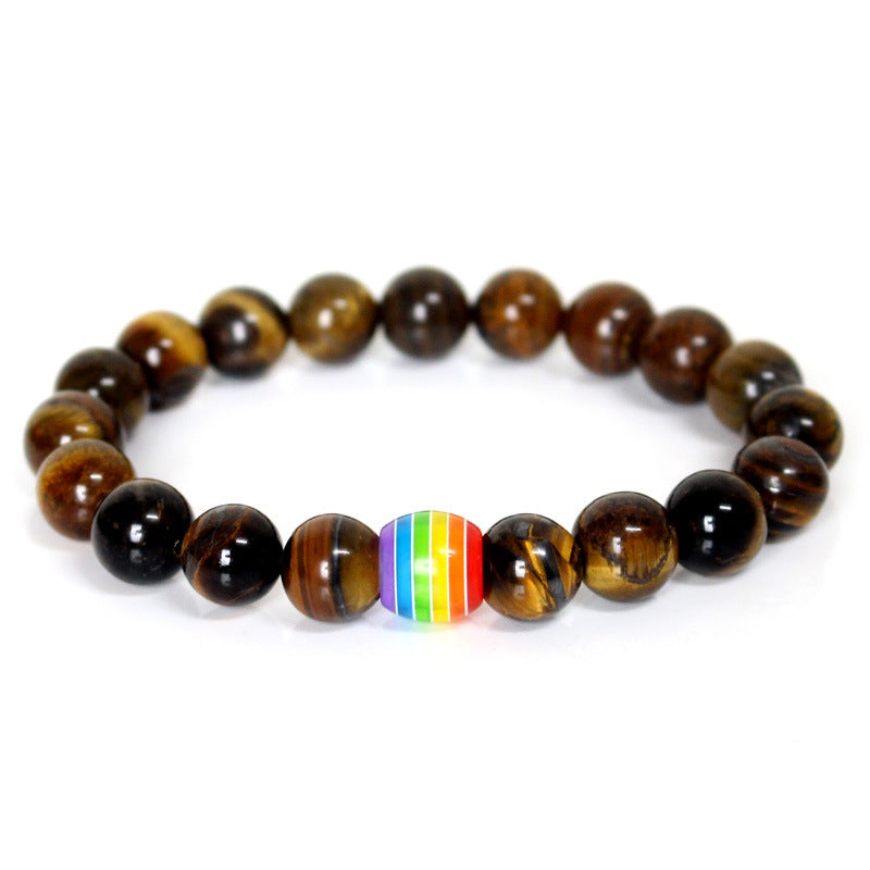 Beaded bracelet with a rainbow heart charm on a white background