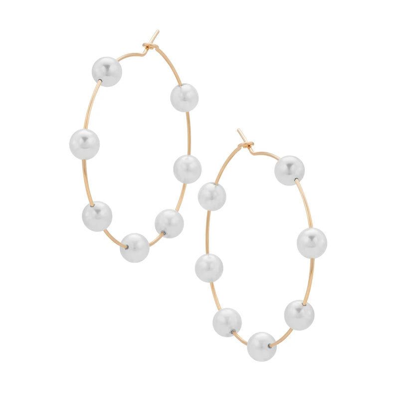 Gold hoop earrings with pearls on a white background