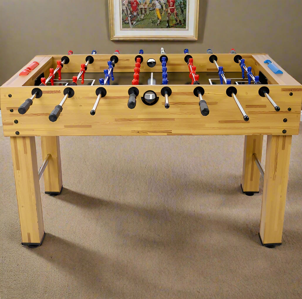 Wooden foosball table with red, blue, and black players on a white background