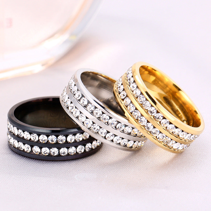 Three rings in black, silver, and gold with diamond-like stones on a light background