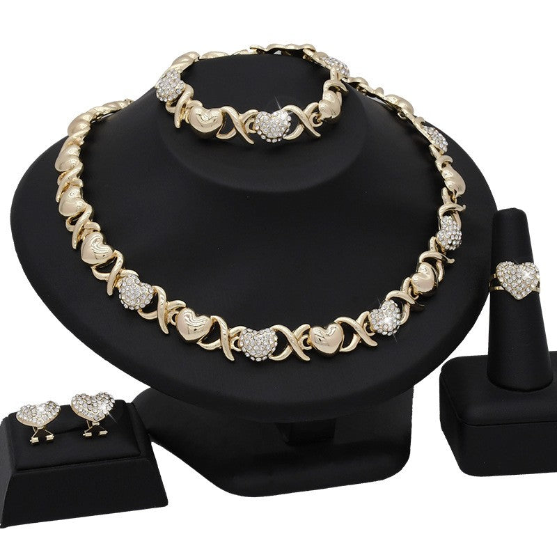 Jewelry set including necklace, bracelet, ring, and earrings on a black stand.
