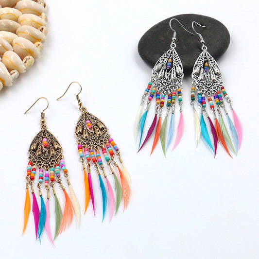 Colorful feather earrings with beaded accents on a white background