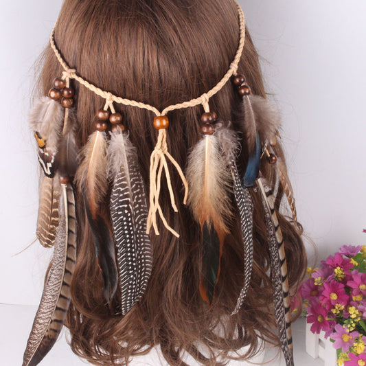 Feather headband with beads on a person's head against a white background