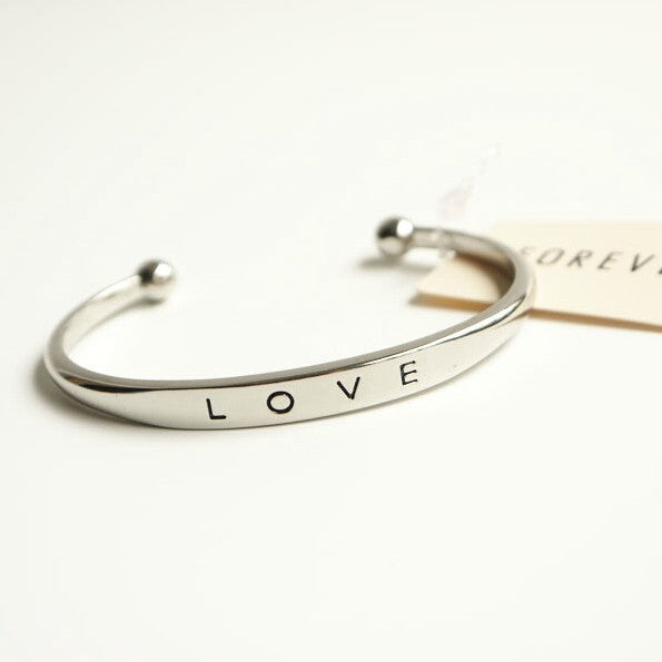 Silver bracelet with 'LOVE' engraving on a white background