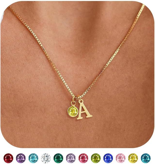 Gold necklace with a yellow gemstone and letter 'A' pendant on a skin-toned background.