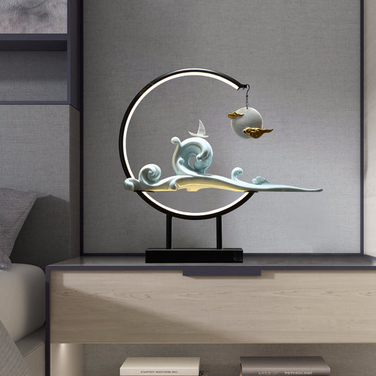 Decorative lamp with wave design on a wooden surface against a gray wall.  incense burner