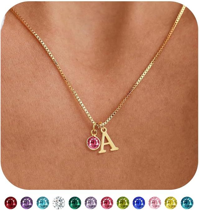 Gold necklace with a pink gemstone and letter 'A' pendant on a skin-toned background.