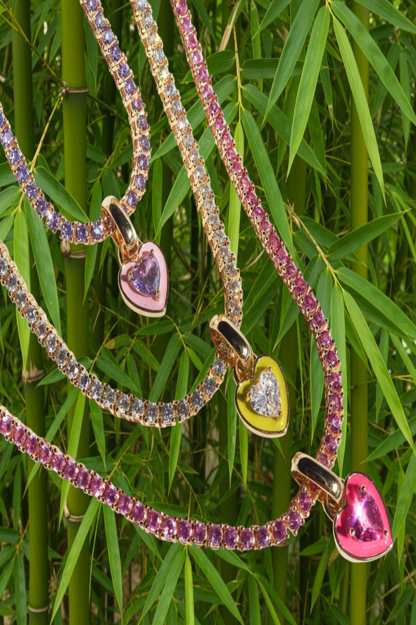 Three colorful heart-shaped pendant necklaces on a white background