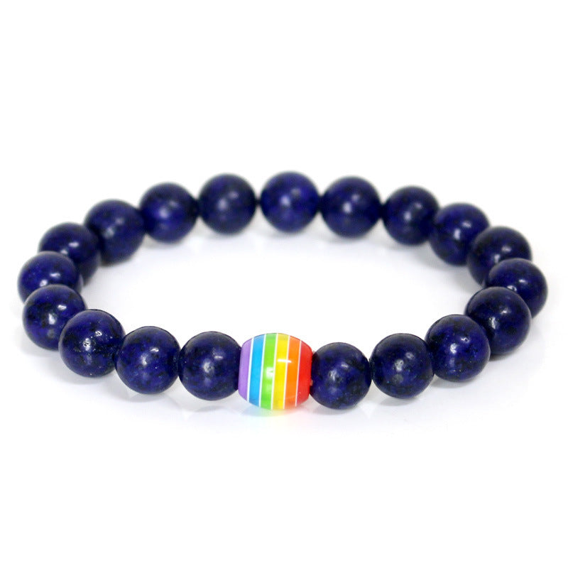 Navy blue beaded bracelet with a rainbow heart charm on a white background