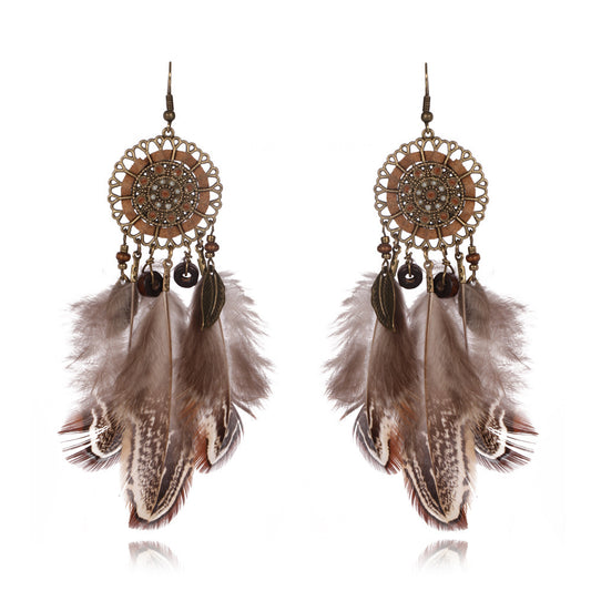 Feathered earrings with decorative elements on a white background