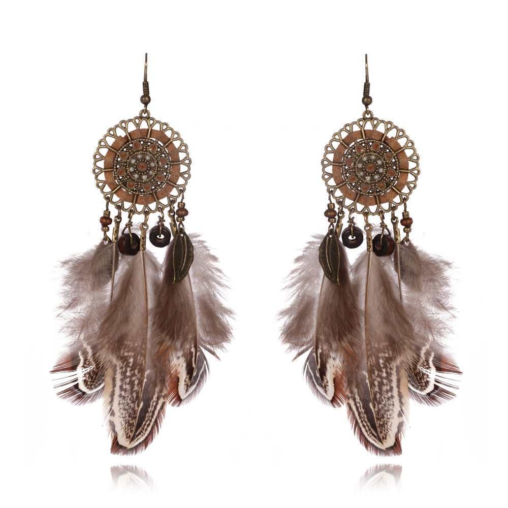 Feathered earrings with decorative elements on a white background