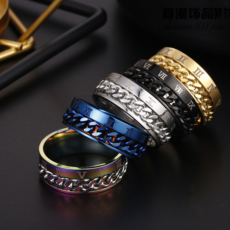 Four metallic rings with chain designs and Roman numeral accents on a dark surface.