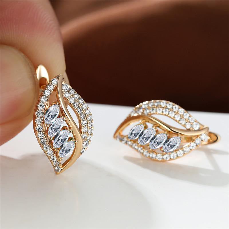 Rose gold earrings with diamond accents on a white surface