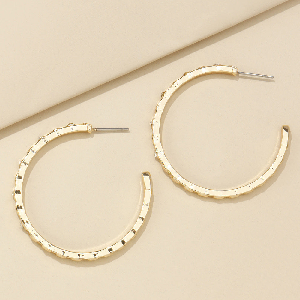 Gold hoop earrings on a beige background