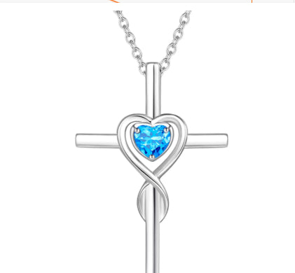 Birthstone  Silver cross necklace with a heart-shaped blue gem on a white background