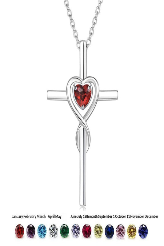 Silver cross necklace with heart-shaped gemstone and color chart on a white background