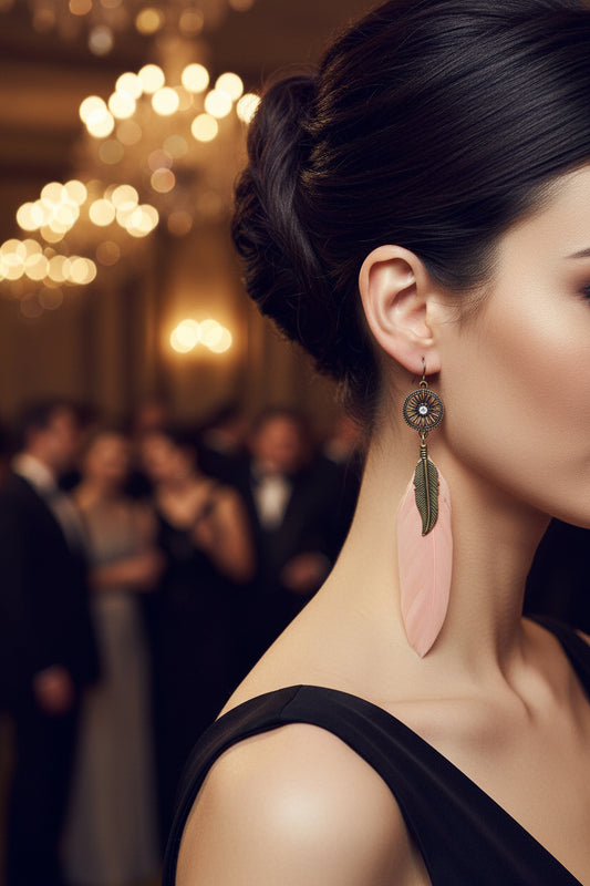 Feather-shaped earrings with pink leaves and gold accents on a dark background