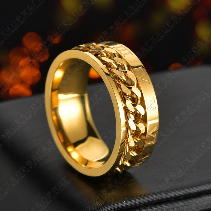 Gold chain-link ring on a dark surface with blurred lights in the background