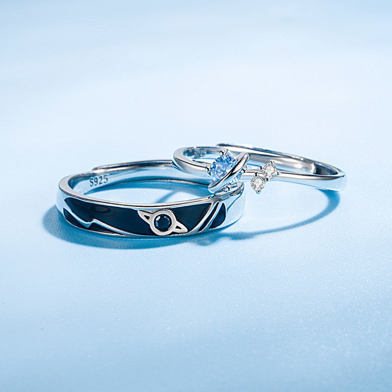 Two silver rings with gemstones on a light blue background