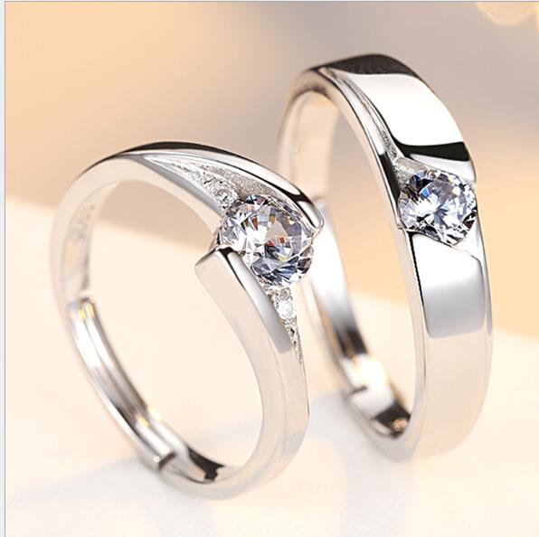 Two silver rings with clear gemstones on a light background