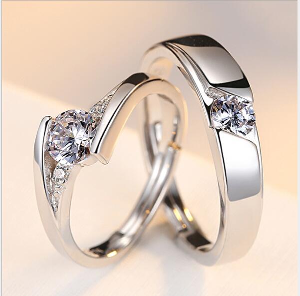 Two silver rings with diamond-like stones on a light background