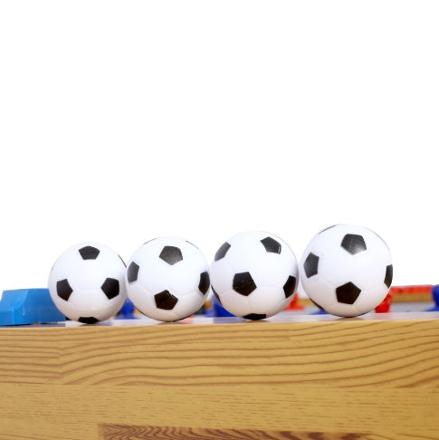 Four soccer balls on a wooden surface with a white background