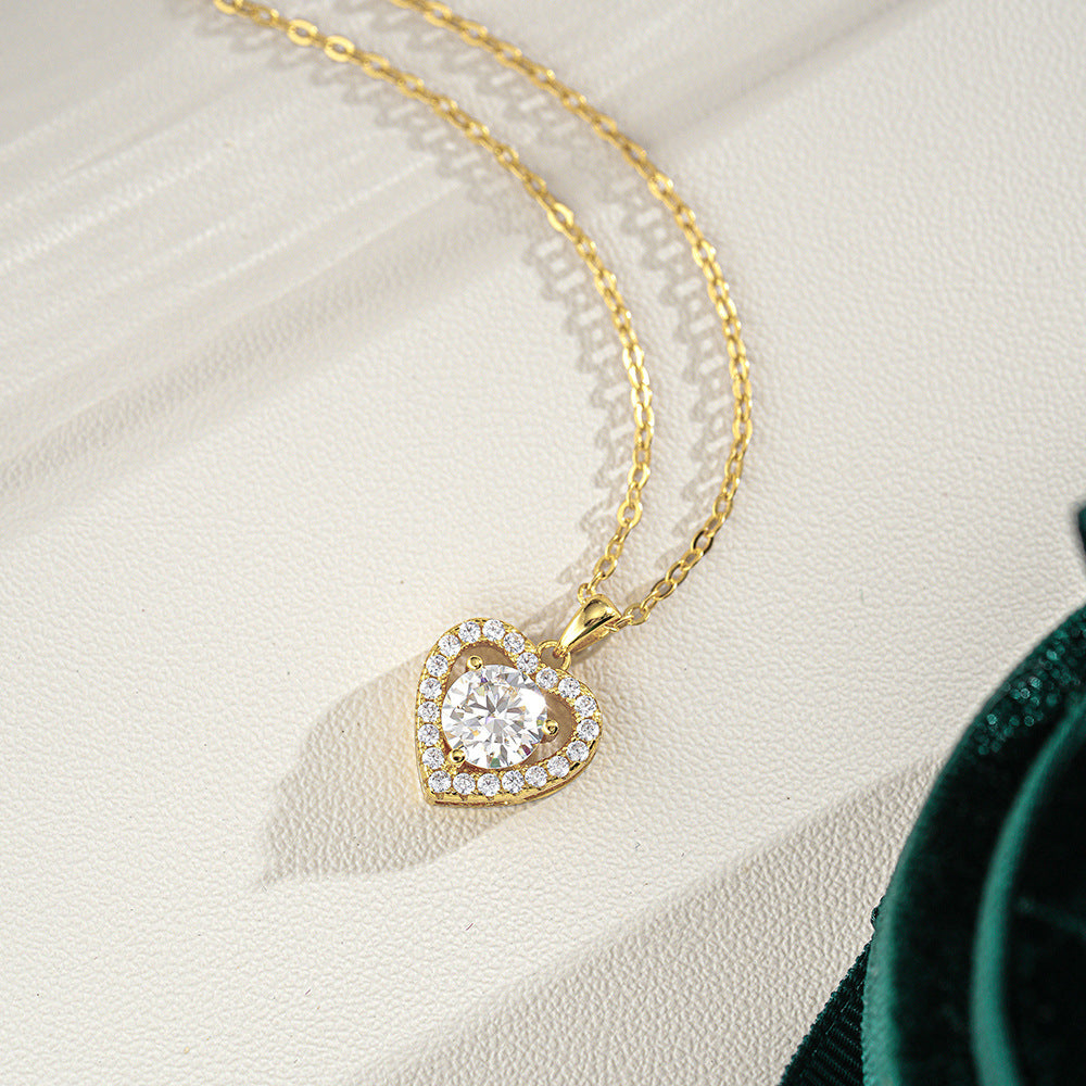 Gold heart-shaped pendant necklace on a white fabric background