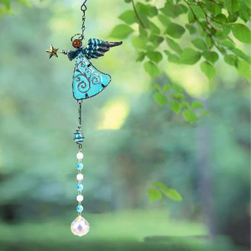 Decorative angel hanging ornament with beads against a blurred green natural background