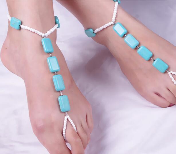 Anklets with turquoise and white beads on a white background