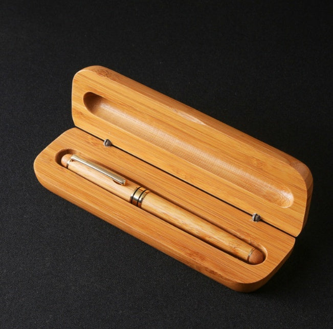 “Bamboo signature pen in solid bamboo gift box on light wood background”