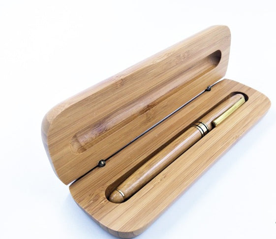 “Bamboo signature pen in solid bamboo gift box on light wood background”