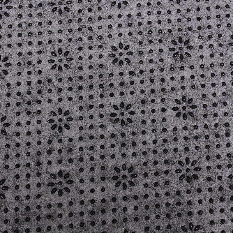 Patterned fabric with black floral shapes on a gray background