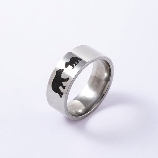 Silver ring with black bear engraving on a white background
