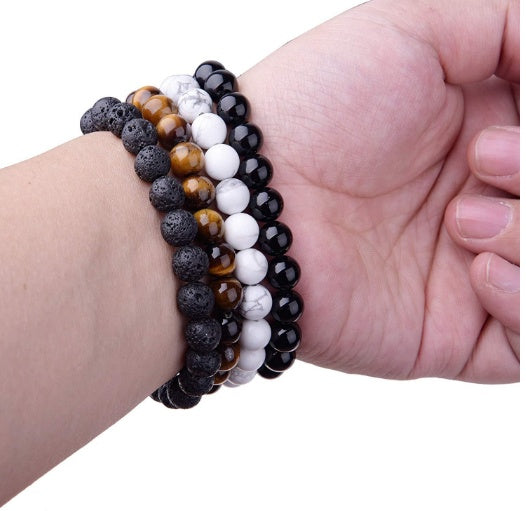 Multicolored beaded bracelet on a wrist against a white background