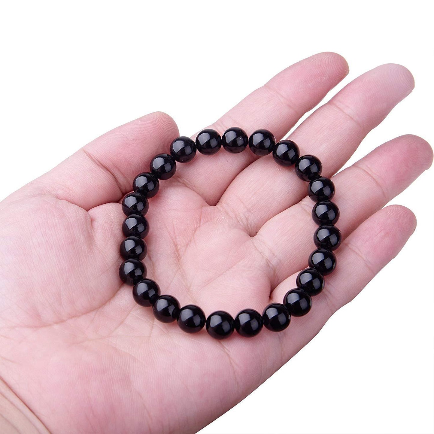 Black beaded bracelet on a hand with a white background