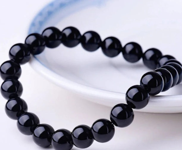 Black onyx beaded bracelet on a white surface