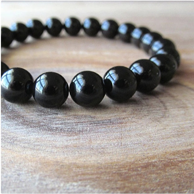 Black onyx beaded bracelet on a wooden surface