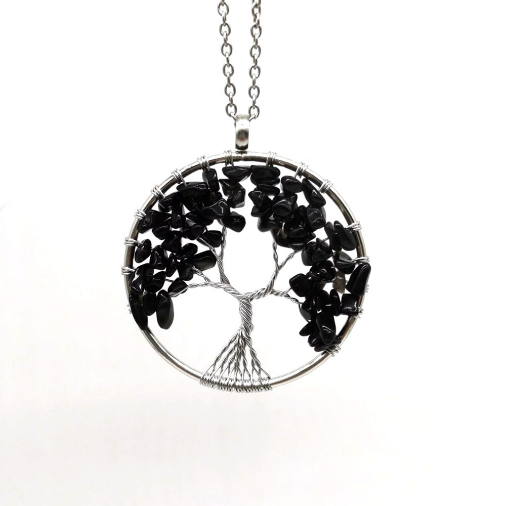 Tree-shaped pendant with black stones on a white background
