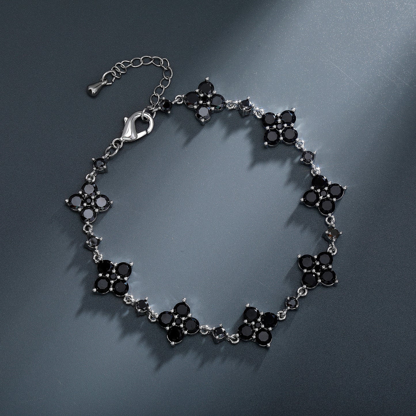 Silver bracelet with black stones on a dark gray background