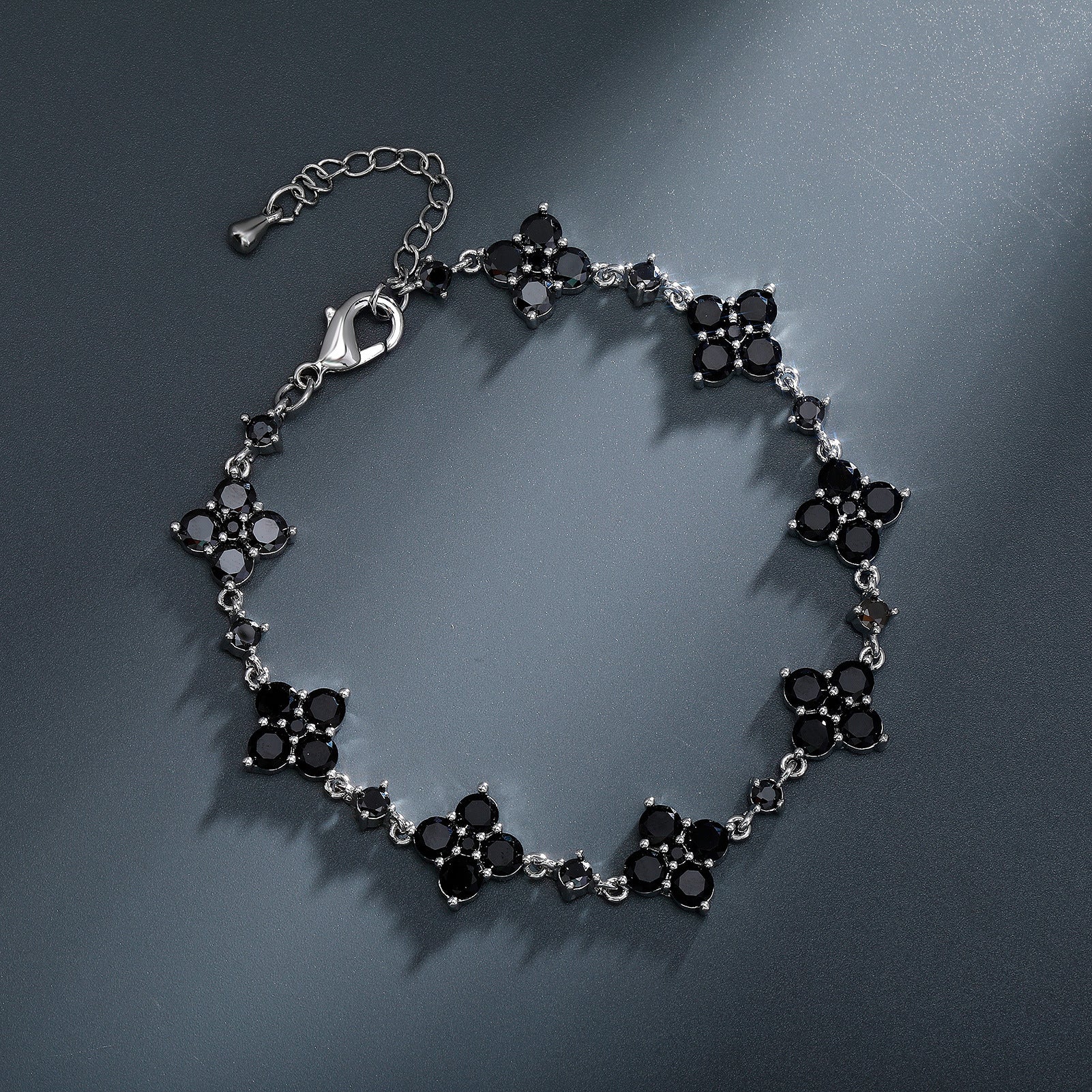Silver bracelet with black stones on a dark gray background