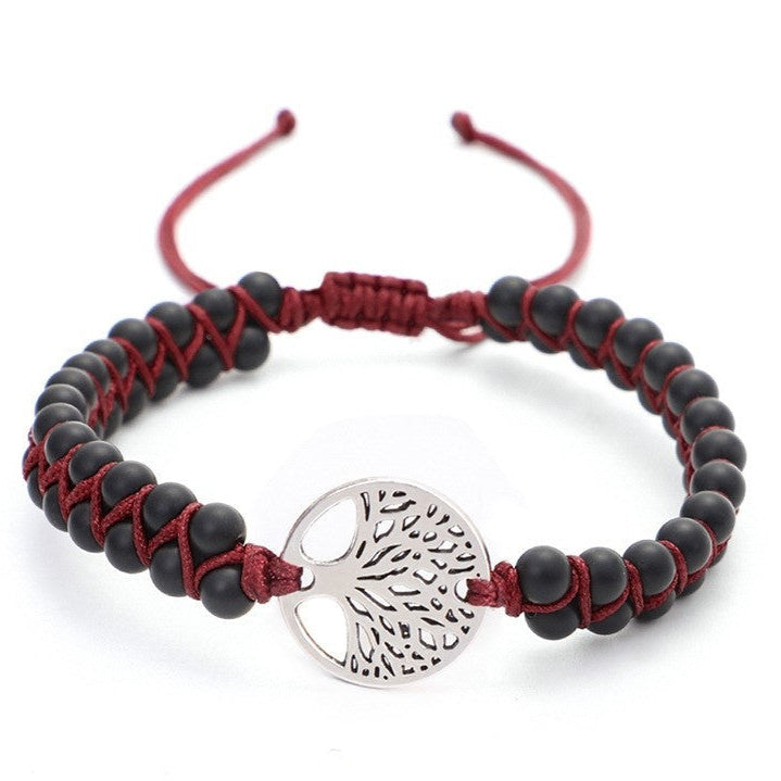 Bracelet with black beads and a silver tree-shaped charm on a white background