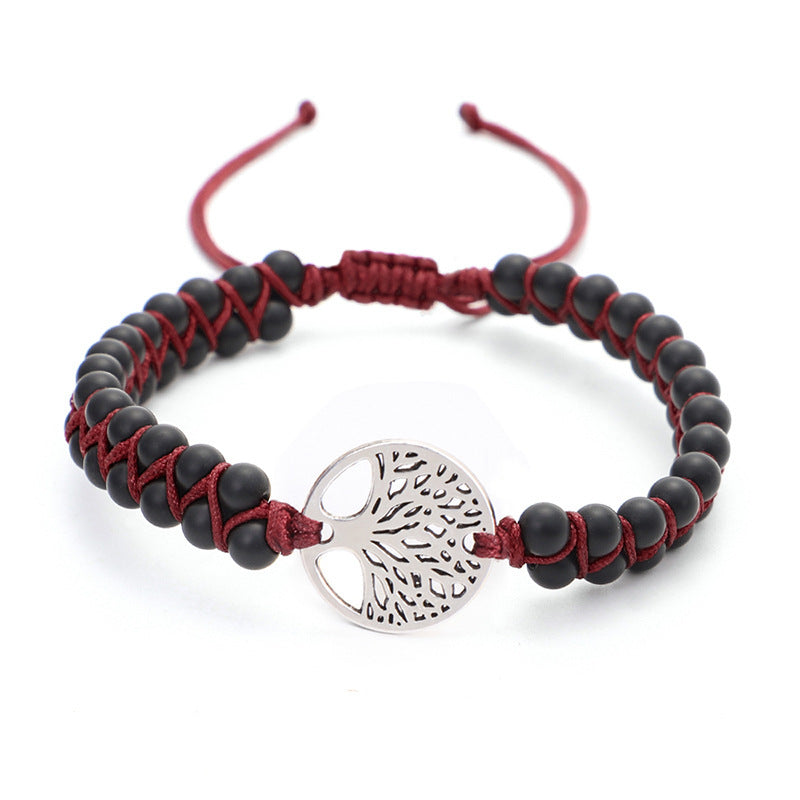 Bracelet with black beads and red cord featuring a silver tree-of-life charm on a white background